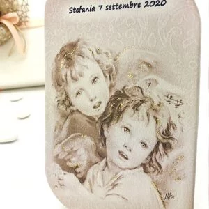 Bomboniera quandro angelo battesimo, icona sacra realizzata in legno con rivestimento in pelle su cui è stampata la dolce immagine di due angeli custodi. Sono arricchiti da glitter oro e possono essere personalizzati con stampa del nome del bambino/bambina e data dell'evento. Raffigurazione ideale per l'utilizzo di questa icona come bomboniere battesimo sacre