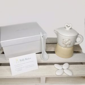 Bomboniera Moka zuccheriera disponibile in 2 modelli. Il coperchio con impugnatura a forma di cuore è in ceramica bianca. Complete di cucchiaino in legno.
