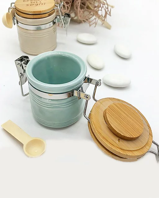 Bomboniera utile Barattoli con cucchiaio colorati realizzati in ceramica ,di forma cilindrica dotati di tappo in legno incisa una frase