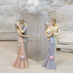 Bomboniera Coppia sposi serena realizzata in resina, grazie ai suoi colori rende la bomboniera originale e moderna. Assortiti in due varianti come dimostrato in foto.