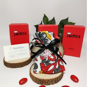 Sacchetto rosso decorato con fantasia maiolica con applicazione ciondolo albero della vita. Adatto anche a tutte le facoltà di laurea. Scegli di ricevere il sacchettino completo di confetti.