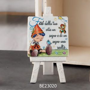 Bomboniera Pinocchio realizzato in polvere di marmo e resina bianca, con al centro un quadretto raffigurante il piccolo Pinocchio