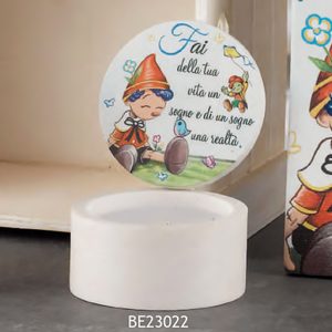 Bomboniera Pinocchio realizzato in polvere di marmo e resina bianca, con al centro un quadretto raffigurante il piccolo Pinocchio