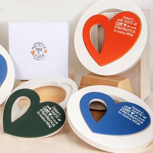 Sottopentola cuore tondo realizzato su base in legno, antiscivolo decorato con fantasia doppio cuore disponibile in tre varianti di colori