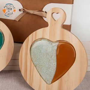 Tagliere bicuore tondo realizzato su base in legno, antiscivolo decorato con fantasia cuore disponibile in tre varianti di colori, ad effetto lucido.