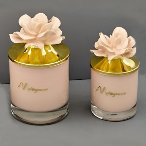 Candela profumata rosa cipria capodimonte realizzata in vetro con un fiore e un tappo oro.