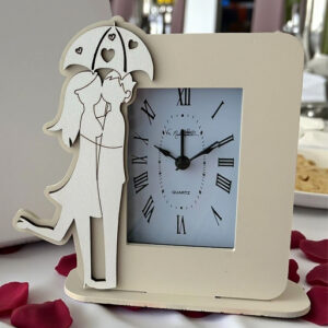 Bomboniera orologio con coppia innamorati abbracciati sotto l'ombrello traforato.
