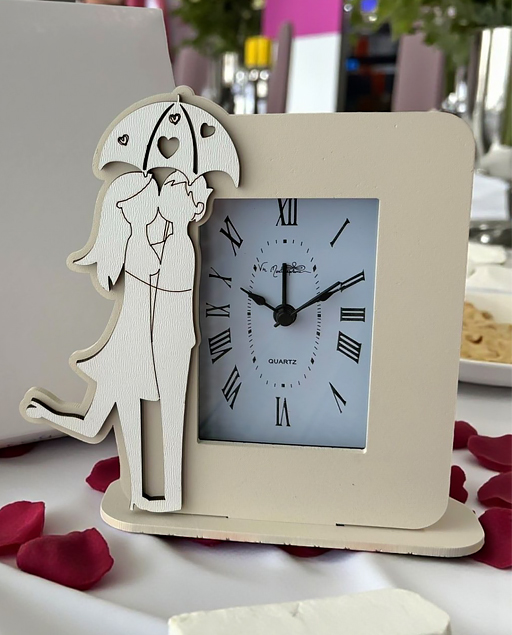 Bomboniera orologio con coppia innamorati abbracciati sotto l'ombrello traforato.