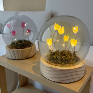 Bomboniera sfera led con fiori led. La sfera con base in legno racchiude muschio e sei fiorellini in plastica