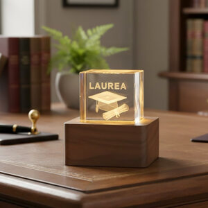 Cubo laurea in cristallo con base in legno. La bomboniera è realizzata in vetro, alla base una luce led rende atmosfera magica